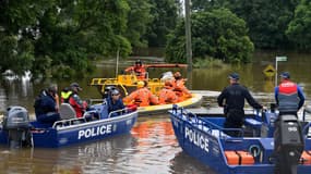 Des membres du service d'urgence de l'État transportent des fournitures médicales et des articles de secours aux résidents touchés par les inondations lors des opérations de sauvetage à Windsor, dans le nord-ouest de Sydney, le 23 mars 2021.