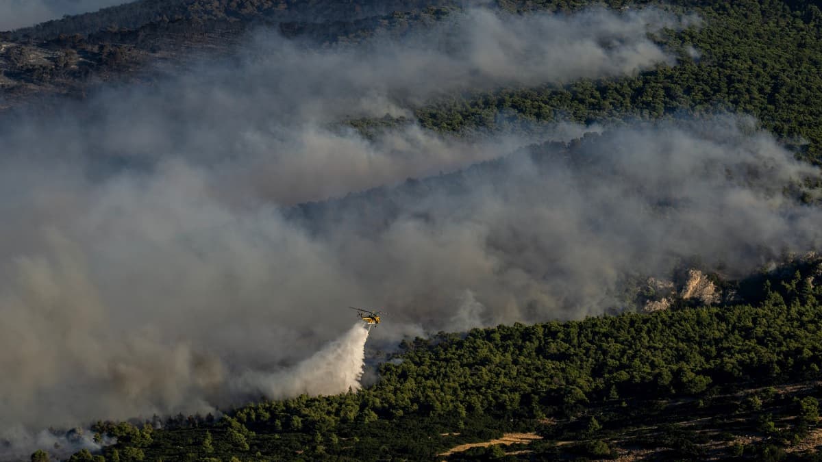 Un hélicoptère largue de l'eau sur un feu de forêt à Porto Germeno, en Grèce, le dimanche 2 août 2026 Un hélicoptère largue de l'eau sur un feu de forêt à Porto Germeno, en Grèce, le dimanche 2 août 2026