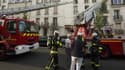 Le 6 juin 2016, des pompiers donnent les premiers secours à une personne âgée qu'ils ont évacuée, tandis qu'ils tentent de venir à bout du feu qui s'est déclenché dans un immeuble de Saint-Denis. (Photo d'illustration) 