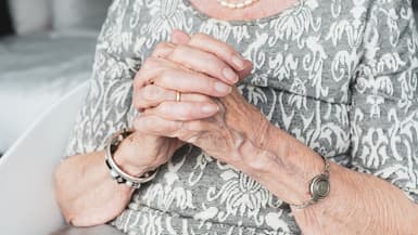 Une femme âgée se tient les mains croisées (photo d'illustration)