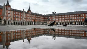 (ARCHIVES) Une personne traverse la Plaza Mayor déserte, le 21 avril 2020, lors du premier confinement décrété en Espagne, alors que la capitale espagnole est frappée à nouveau par un confinement partiel, comme d'autres villes et régions, face à la reprise de l'épidémie de coronavirus (photo d'illustration)