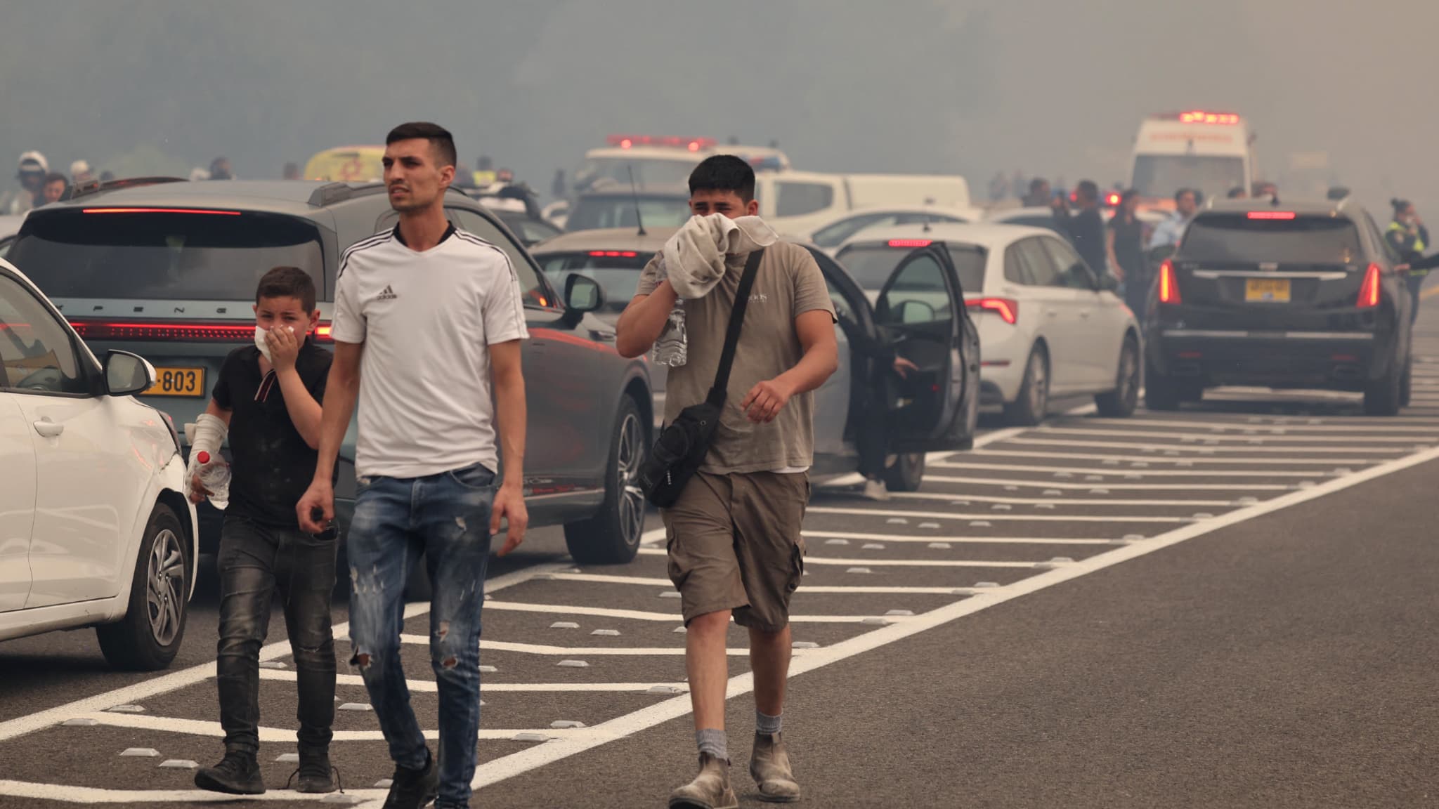 People evacuate a road due to a fire in a forest in Bet Shemesh, near Jerusalem, on April 30, 2025.