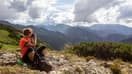Une femme au sommet d'une montagne après une randonnée.