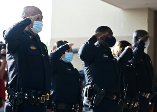 Des policiers saluent le cercueil de George Floyd à son arrivée à l'église Fountain of Praise à houston, le 9 juin 2020 Des policiers saluent le cercueil de George Floyd à son arrivée à l'église Fountain of Praise à houston, le 9 juin 2020