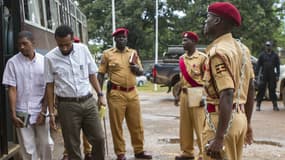 Les forces de sécurités ougandaises escortent des hommes suspectés d'avoir participé au double attentat de 2010 de Kampala, ici le 26 mars 2015. 