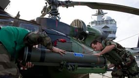 Préparation d'un hélicoptère d'attaque sur le pont du navire français Tonnerre, croisant en Méditerranée. Des hélicoptères d'attaque français et britanniques sont pour la première fois entrés en action vendredi soir contre l'armée libyenne, accentuant la