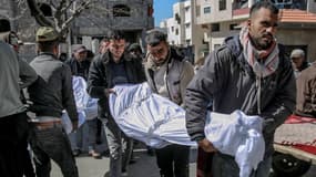 Des hommes transportent un corps à Gaza, après des tirs israéliens qui ont fait plus de 110 morts selon le Hamas le 29 février 2024