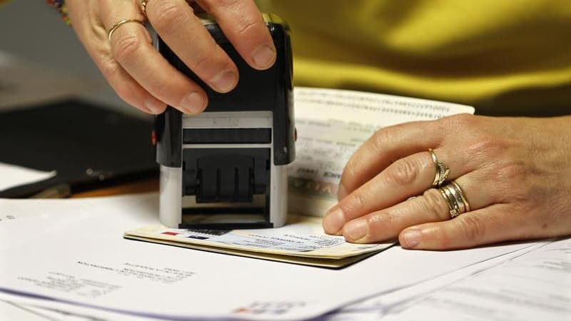 Apposition d'un visa sur un passeport, à Paris.