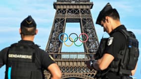 Des gendarmes devant la Tour Eiffel et les anneaux olympiques, à Paris le 19 juin 2024.