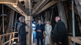 Emmanuel Macron et Brigitte Macron visitent la cathédrale Notre-Dame de Paris à Paris, le 29 novembre 2024 et se tiennent à côté d'un morceau de charpente en bois.