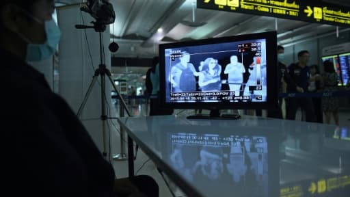 Un employé thaïlandais surveille les arrivées de passagers à l'aéroport de Suvarnabhumi à Bangkok, le 19 juin 2015