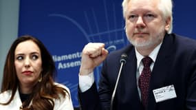 Julian Assange, aux côtés de son épouse Stella Assange, lève le poing lors d'une audition parlementaire au Conseil de l'Europe à Strasbourg, le 1er octobre 2024.