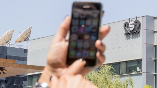 Une femme montre son téléphone devant le siège de l'entreprise NSO, qui a conçu un logiciel espion, le 28 août 2016 à Herzliya, en Israël