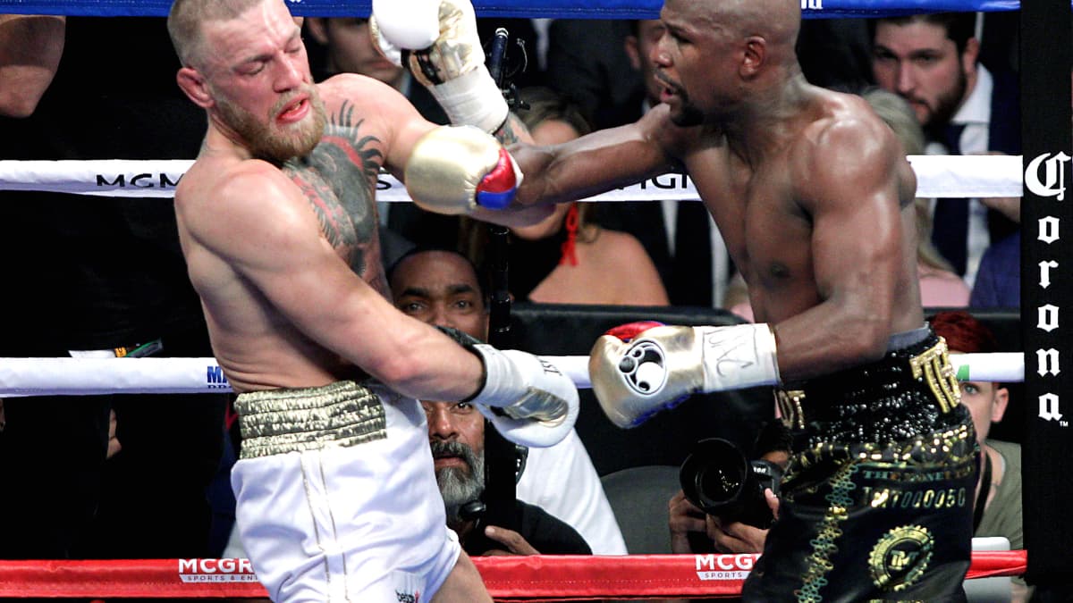 Conor McGregor (à gauche) et Floyd Mayweather lors de leur combat en août 2017 Conor McGregor (à gauche) et Floyd Mayweather lors de leur combat en août 2017