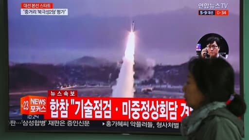 Une femme passe devant un écran de télévision montrant un nouveau tir de missile en Corée du nord, le 5 avril 2017 à Séoul