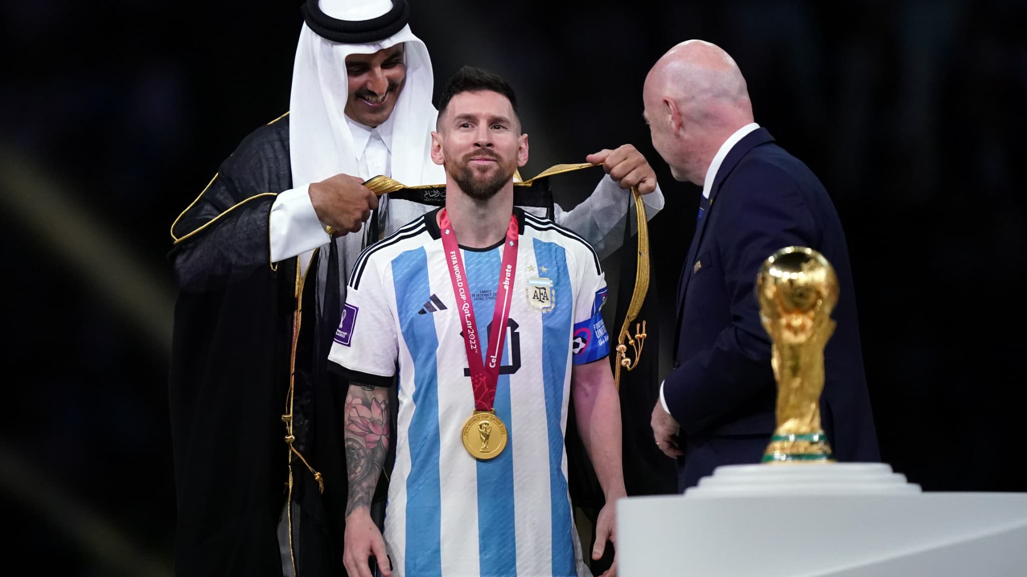 L'émir du Qatar posant un bisht sur les épaules de Lionel Messi