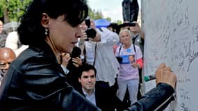 Rachida Dati écrit un mot sur le mur aux signatures consacré à Nicolas Sarkozy, à la Ferté-Imbault le 5 juillet dernier.
