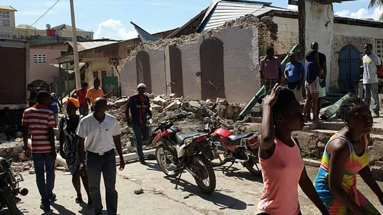 Des habitants regardent les maisons effondrés dans la ville de Jérémie après le séisme qui a frappé le sud-ouest d'Haïti, le 14 août 2021