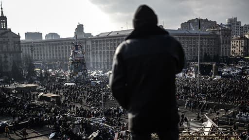 Des Ukrainiens se réunissent sur la place de l’Indépendance qui porte encore les traces des combats de la veille.