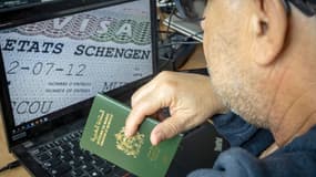 Un Marocain tient son passeport devant son ordinateur qui affiche un visa Schengen en septembre 2021 (photo d'illustration)