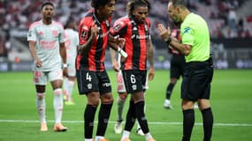 L'arbitre de Nice-Lyon Jérome Brisard discutant avec le capitaine niçois Dante