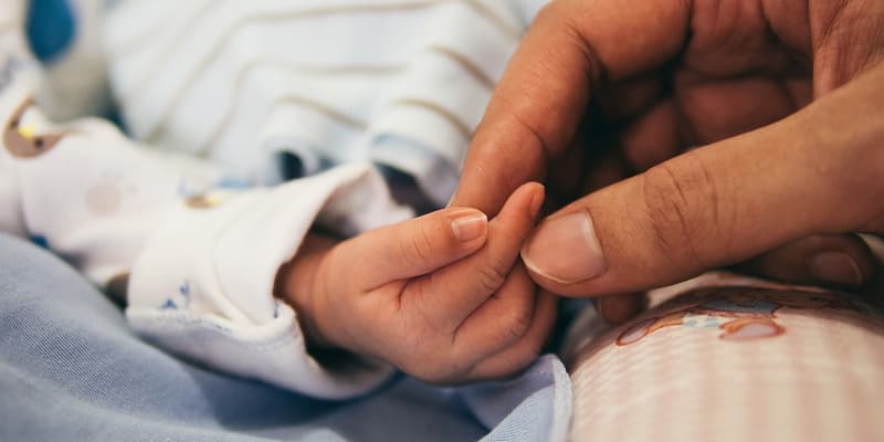 Un parent tient la main de son bébé (photo d'illustration). 