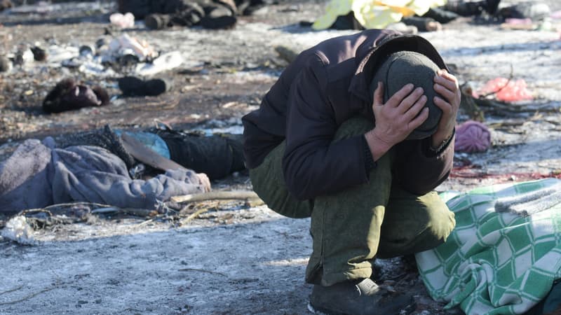 Un homme pleure à côté du corps de sa femme tuée à la suite d'une frappe de missile à Donetsk le 21 janvier 2024, au milieu du conflit russo-ukrainien en cours.