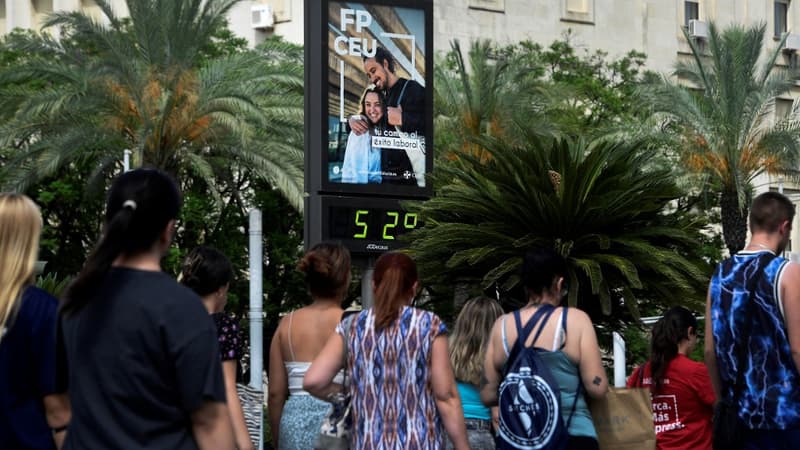 Des piétons passent devant un panneau indiquant une température de 52°C pendant une vague de chaleur à Séville, le 10 juillet 2023.