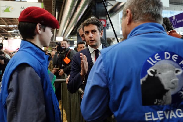 Le Premier ministre français Gabriel Attal s'entretient avec des éleveurs lors de sa visite au Salon international de l'agriculture à Paris, le 27 février 2024.

