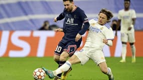 Le milieu de terrain croate du Real Madrid, Luka Modric, dégage le ballon devant l'attaquant argentin du Paris Saint-Germain, Lionel Messi, lors du 8e de finale retour de la Ligue des Champions, le 9 mars 2022 au Stade Santiago Bernabeu