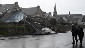 Des piétons passent devant un entrepôt détruit à Porspoder (Finistère) par la tempête Ciarán, le 2 novembre 2023.