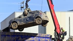 Une grue déplace une voiture immobilisé par la montée des eaux à Paiporta, près de Valence, le 10 novembre 2024