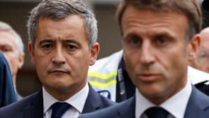 Le ministre de l'Intérieur Gérald Darmanin se tient aux côtés du président Emmanuel Macron lors d'une visite au collège-lycée d'Arras, le 13 octobre 2023, après le meurtre d'un professeur poignardé à mort par un jeune homme fiché pour radicalisation