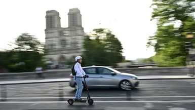 Un homme passe en trottinette électrique devant la cathédrale Notre-Dame de Paris le 23 août 2023