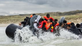 Des migrants embarquent à bord d'un canot pneumatique pour tenter de traverser la Manche, sur la plage d'Ecault à Saint-Etienne-au-Mont, près de Neufchâtel-Hardelot, dans le nord de la France, le 30 octobre 2024. 