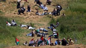 Manifestants se mettant à couvert lors d'une manifestation près du village druze de Majdal Shams sur le plateau du Golan, près de la frontière entre la Syrie et Israël. Des soldats israéliens ont ouvert le feu dimanche sur des centaines de Palestiniens qu