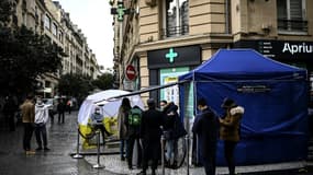 Des personnes attendent de se faire tester au Covid-19 devant une pharmacie, le 23 décembre 2020 à Paris 