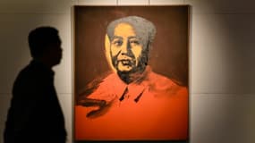Un homme marche le 17 mars 2017 devant le portrait de Mao Tsé-toung par Warhol qui s'est vendu aux enchères le 3 avril à Hong Kong