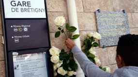 Un homme dépose une rose blanche à la gare de Bretigny-sur-Orge, photo du 12 juillet 2014