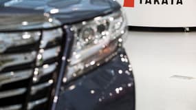 Le logo de l'équipementier automobile japonais Takata est visible à côté d'une voiture dans un showroom à Tokyo, le 23 juin 2017.
