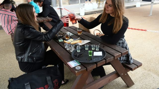Des clients sirotent leur boisson sur la terrasse du Wetherspoons pub à Glasgow en Ecosse, le 26 avril 2021