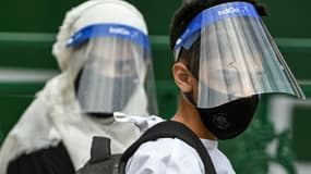 Des personnes portant des visières de protection dans un centre de tests du Covid-19 à Srinagar, dans le Cachemire indien, le 16 juillet