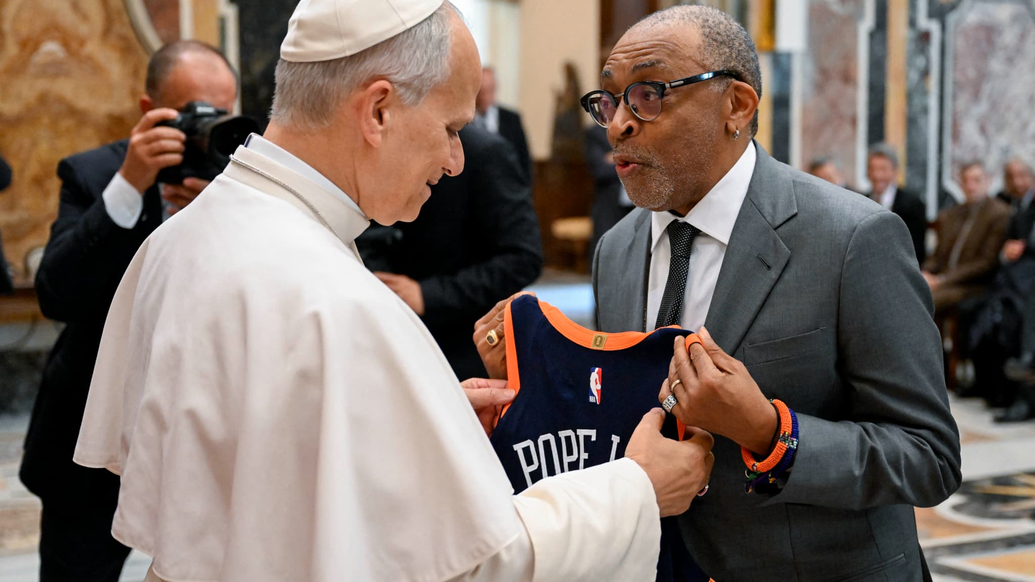 Cette photo prise et diffusée le 15 novembre 2025 par Vatican Media montre le pape Léon XIV rencontrant le réalisateur américain Spike Lee, lors d'une audience avec des artistes du monde du cinéma au Vatican. 