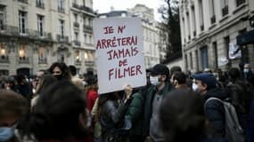 Un manifestant porte une pancarte "Je n'arrêterai jamais de filmer" lors d'un rassemblement contre la proposition de loi sur la "sécurité globale" à l'appel des syndicats de journalistes et de diverses organisations, à Paris le 17 novembre 2020