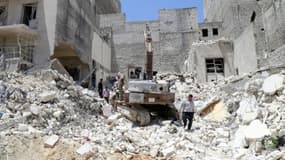 Des personnes inspectent les décombres après un bombardement aérien du régime syrien sur Alep, le 24 mai 2015