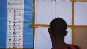 Un habitant de Kinshasa consulte les résultats de la présidentielle affichés devant son bureau de vote. Les partis d'opposition de République démocratique du Congo (RDC) ont récusé samedi les résultats partiels publiés par la commission électorale donnant