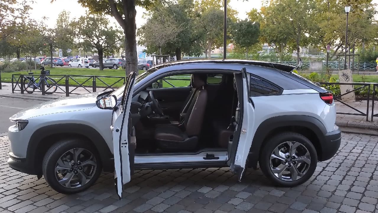 Une portière avant qui s'ouvre à angle droit, une portière arrière antagoniste, Mazda cultive l'originalité sur le MX-30. Une portière avant qui s'ouvre à angle droit, une portière arrière antagoniste, Mazda cultive l'originalité sur le MX-30.