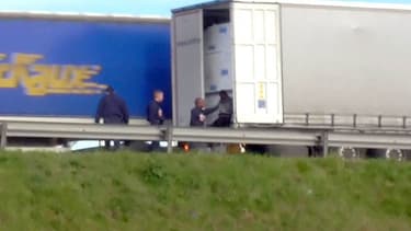 Des CRS évacue un migrant d'un camion