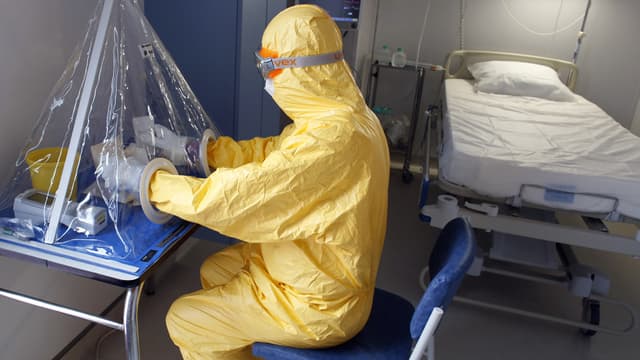 A l'hôpital Bégin le 4 septembre 2014 à Saint-Mandé, un personnel médical des armées fait la démonstration, en tenue de protection, des instruments requis pour traiter les malades d'Ebola.