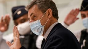 L'ancien président Nicolas Sarkozy salue d'un geste les policiers au dernier jour de son procès pour corruption le 10 décembre 2020 au Palais de justice de Paris 